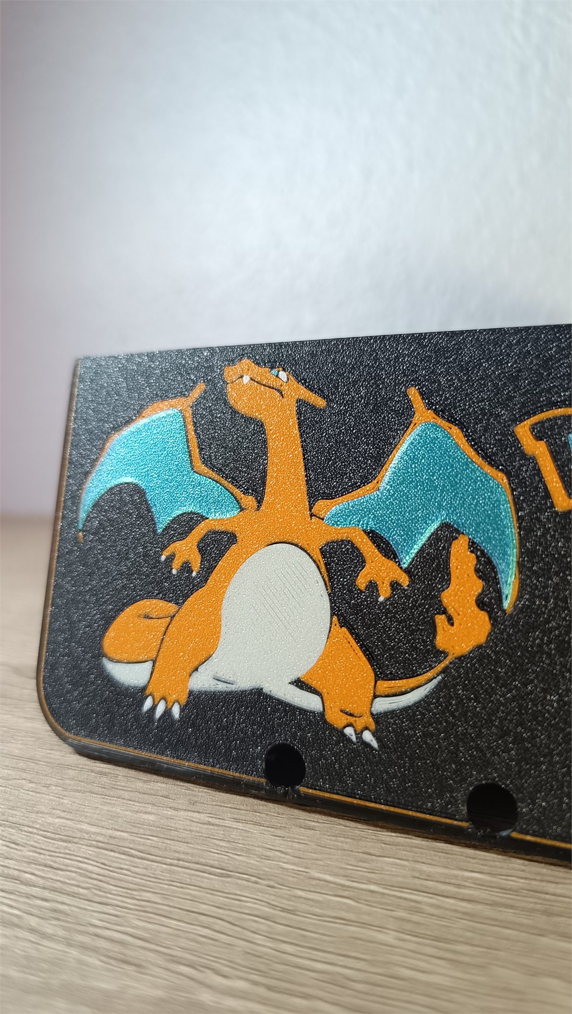 Detalle del relieve de Charizard en la carcasa