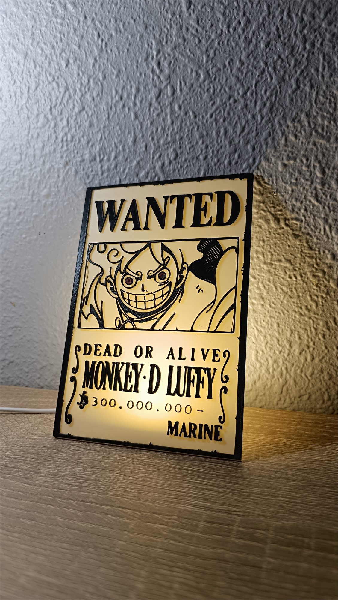 Cartel Wanted Gear 5 blanco apoyado sobre una mesa